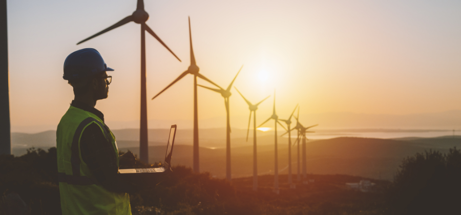 Man at wind farm with tablet
