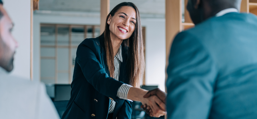 Woman smiling and shaking hand with man