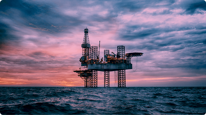 Oil driller in the middle of the ocean with sunset in the background