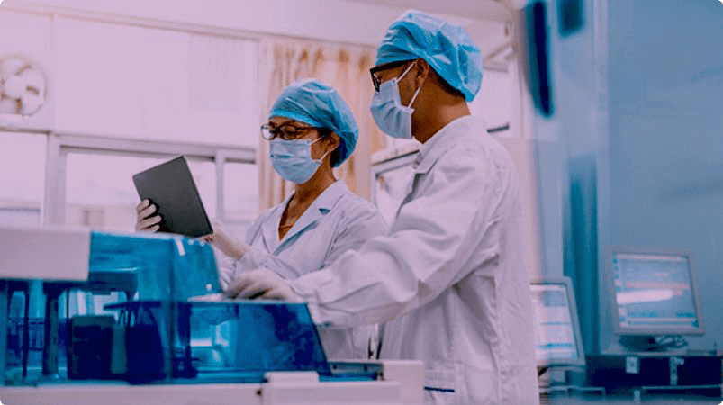 Two doctors with masks looking at tablet