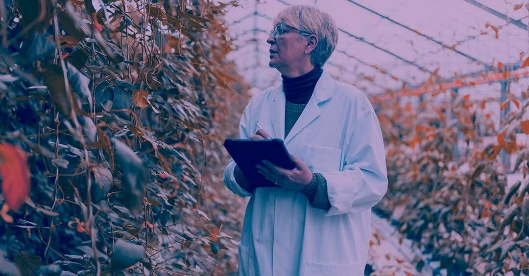 Woman with lab coat inside a greenhouse